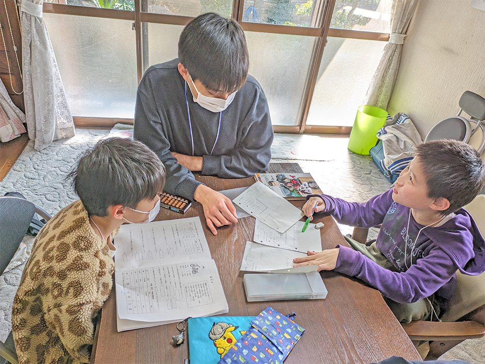 福岡教育大の学生ボランティアと子どもたち。分からないところを質問中