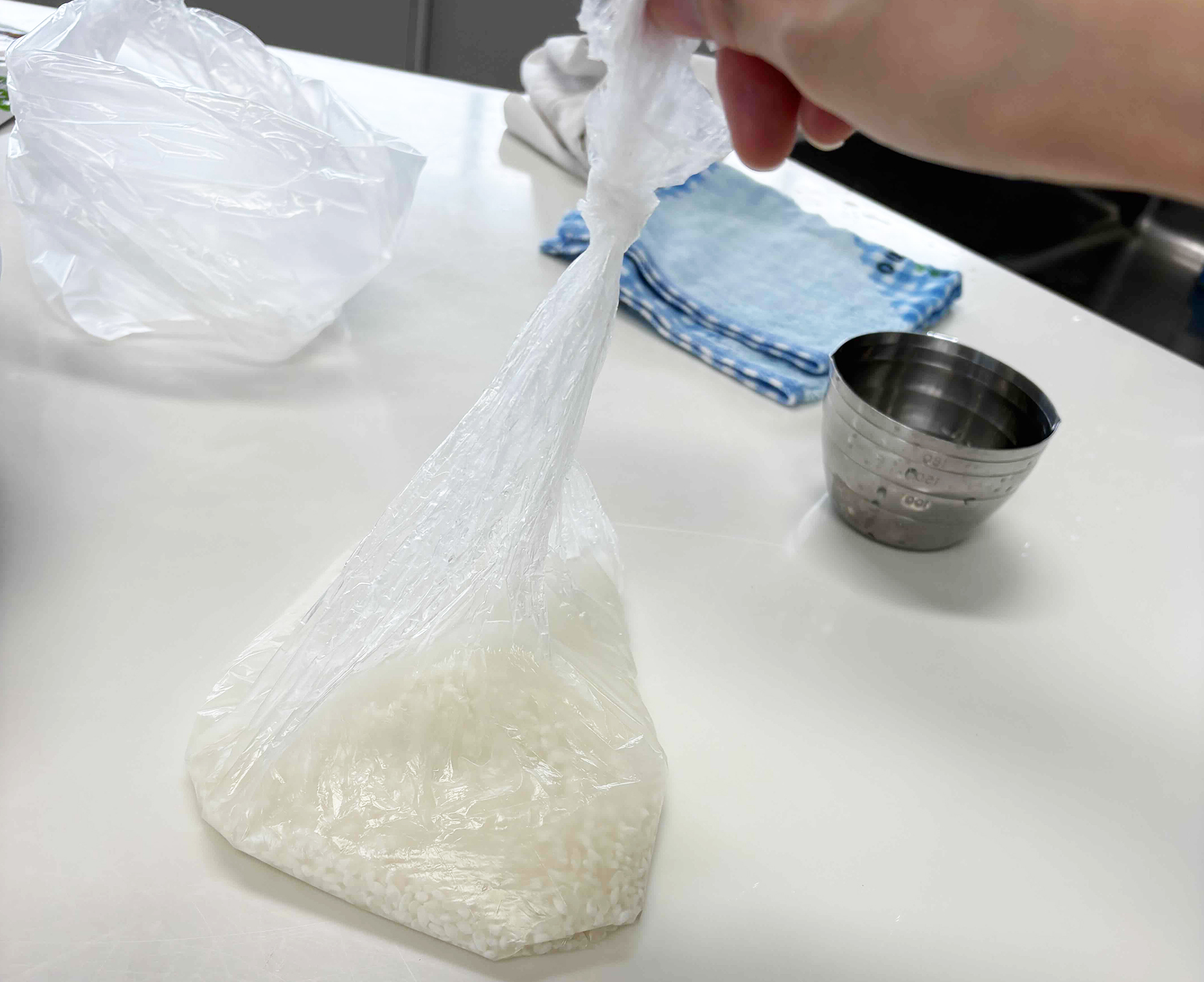 06-ポリ袋の空気をできる限り抜いて、上の方で口を結び夏は30分、冬は60分置いてお米に充分水を含ませます