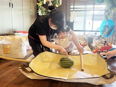 利用者様がスイカ割りをする様子。スイカが割れるとスイカの甘い香りが広がってきました。割れたスイカは利用者様がミキサーにかけて実際に試食もされます。